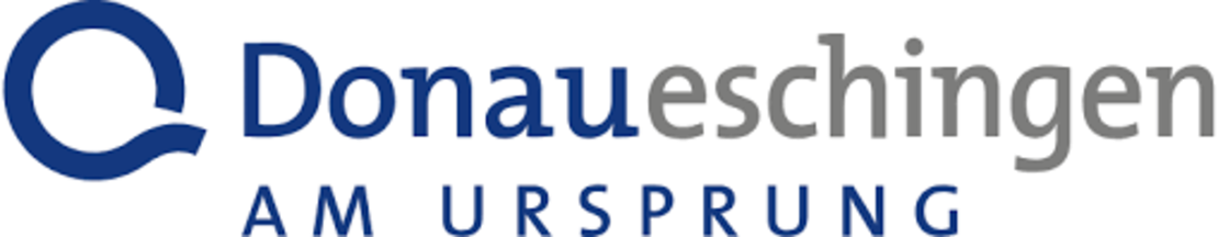 Logo für Donaueschingen mit einer blauen Kreisgrafik auf der linken Seite und dem Text "Donaueschingen AM URSPRUNG" in blau und grau auf weißem Hintergrund.