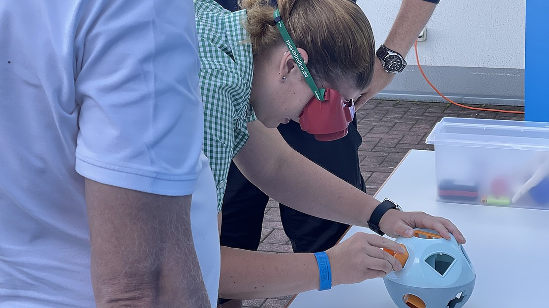 Personen testen ihre motorischen Fähigkeiten mit Kinderspielzeug.
